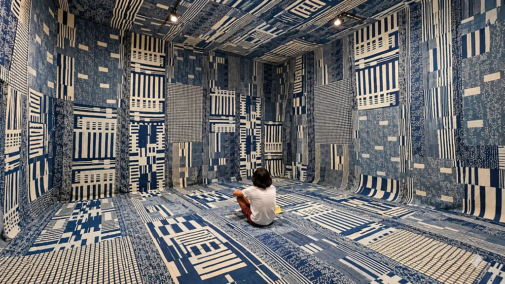 Person immersed in a contemporary textile art installation, illustrating how cultural experiences can earn genuine audience attention.